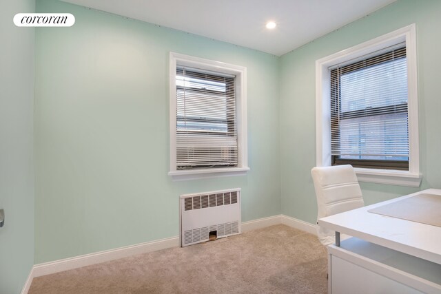 unfurnished office with radiator heating unit, light colored carpet, healthy amount of natural light, baseboards, and recessed lighting