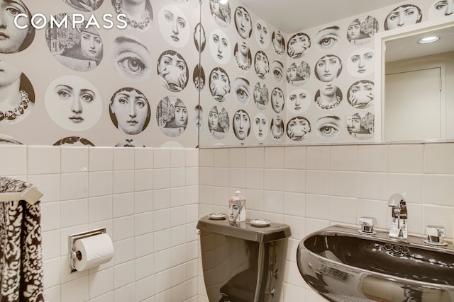 half bathroom with a sink and tile walls