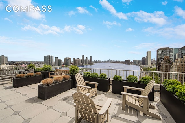 view of patio / terrace featuring a view of skyline, a water view, and a balcony