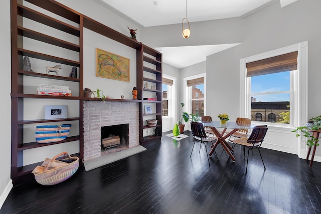 dining area featuring a fireplace, wood finished floors, and baseboards