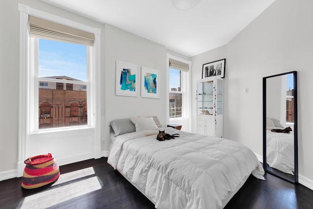 bedroom featuring multiple windows, dark wood-style flooring, and baseboards