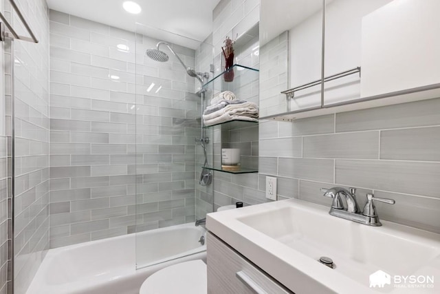 317 E 3rd St Unit 8, New York City, NY 10009 - bathroom featuring toilet, vanity, shower / bath combination, decorative backsplash, and tile walls