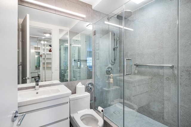 bathroom featuring a stall shower, toilet, and vanity