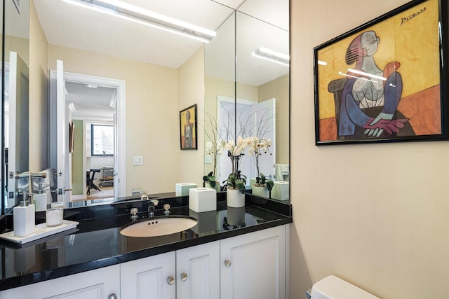 half bathroom with vanity and toilet