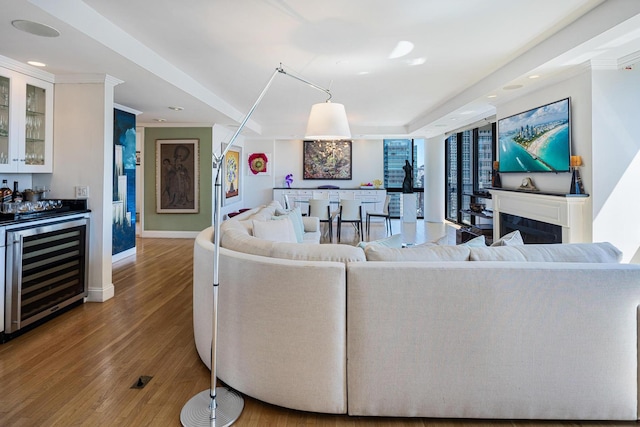 living area featuring beverage cooler, bar area, baseboards, wood finished floors, and recessed lighting