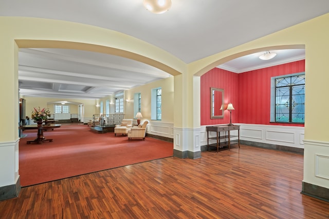 community lobby with crown molding, wainscoting, and a decorative wall