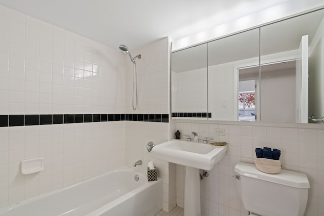bathroom featuring tile walls, toilet, and  shower combination