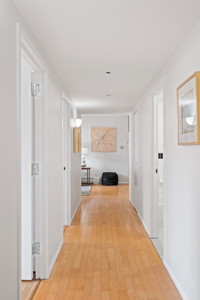 hallway with baseboards and light wood-style flooring