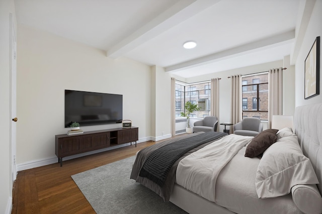 bedroom featuring beam ceiling, wood finished floors, and baseboards