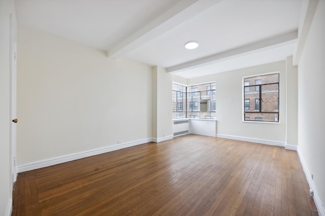 unfurnished room featuring radiator, beamed ceiling, hardwood / wood-style flooring, and baseboards
