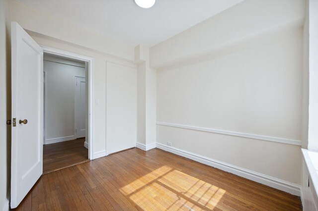 unfurnished bedroom featuring hardwood / wood-style floors and baseboards