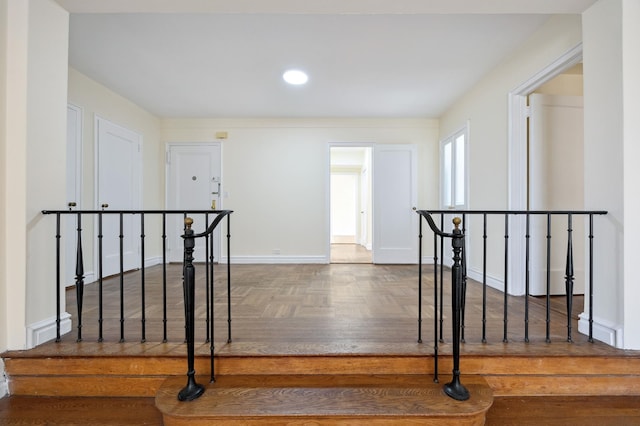 hallway with an upstairs landing and baseboards