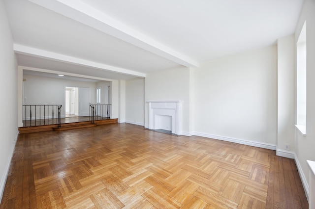 unfurnished living room with baseboards