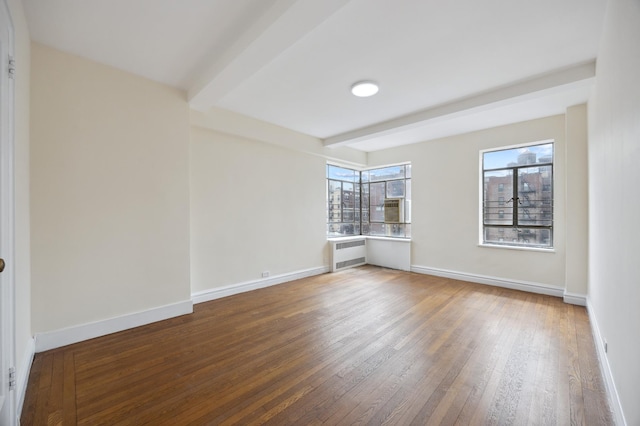 empty room with beam ceiling, radiator heating unit, wood-type flooring, and baseboards