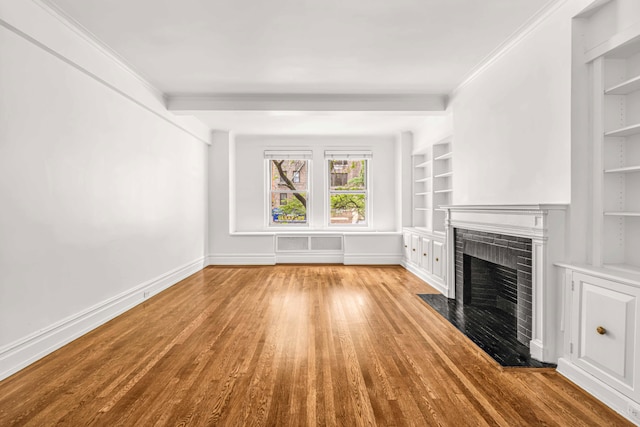 345 E 57th St Unit 2B, New York City, NY 10022 - unfurnished living room featuring ornamental molding, a fireplace, wood finished floors, baseboards, and built in shelves