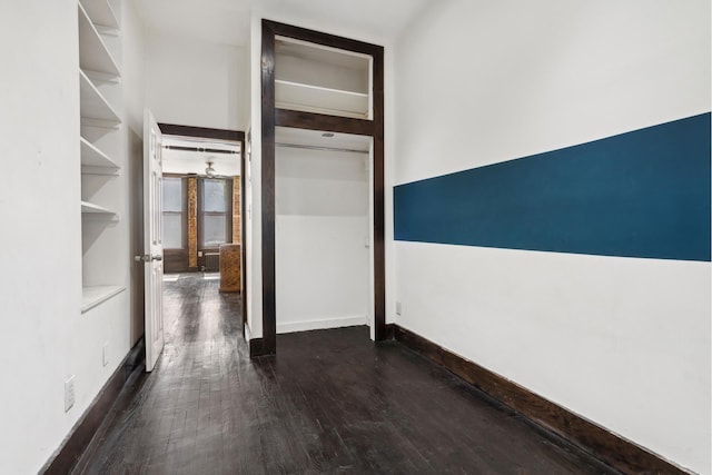corridor with wood finished floors and baseboards