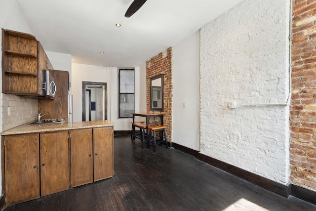 kitchen featuring open shelves, a sink, dark wood-style floors, brown cabinetry, and a peninsula