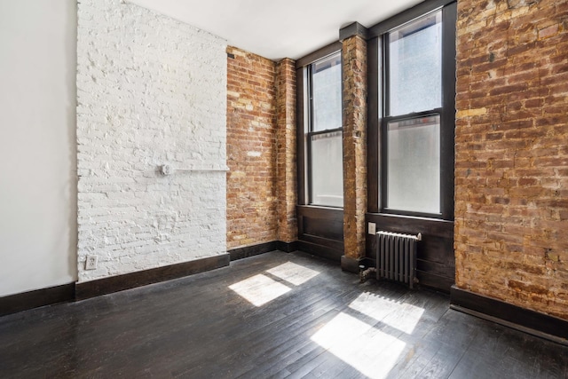 unfurnished room featuring radiator heating unit, dark wood-type flooring, and baseboards