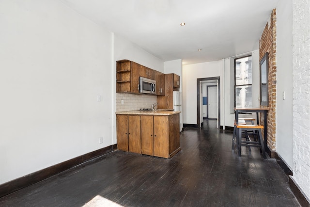 kitchen with stainless steel microwave, dark wood-style floors, open shelves, light countertops, and backsplash