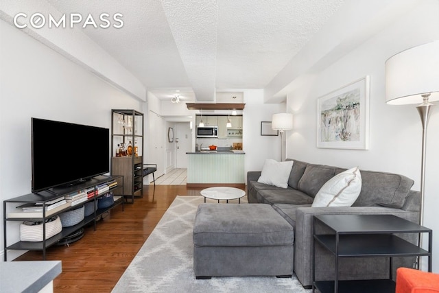 living area featuring wood finished floors and a textured ceiling