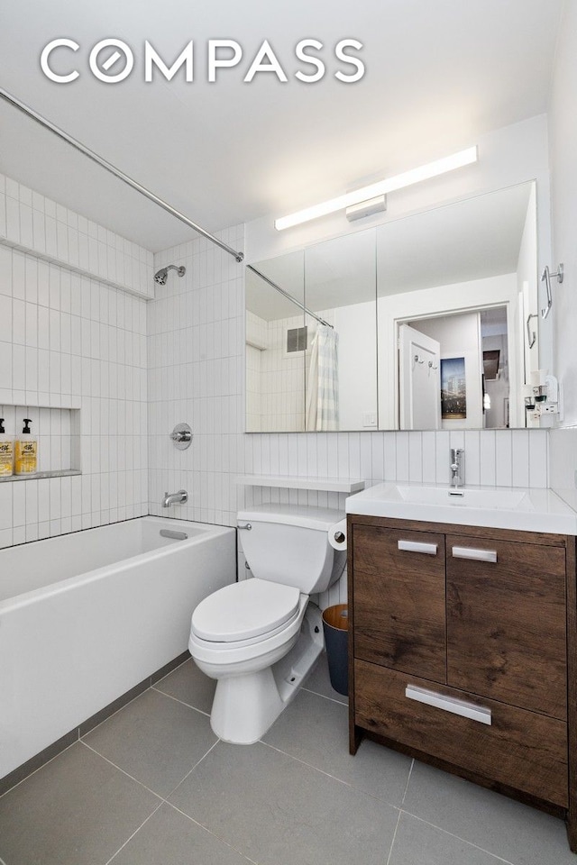full bath with tile patterned flooring, toilet, shower / bathtub combination with curtain, vanity, and tile walls