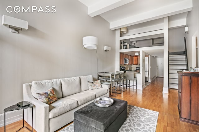 350 E 62nd St Unit 4B, New York City, NY 10065 - living area with light wood-style flooring, stairway, and beam ceiling