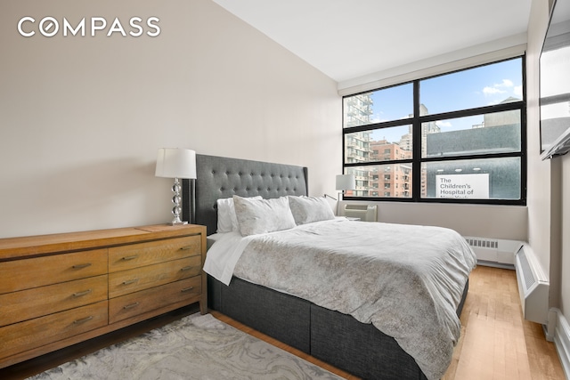 350 E 62nd St Unit 4B, New York City, NY 10065 - bedroom featuring light wood finished floors and vaulted ceiling
