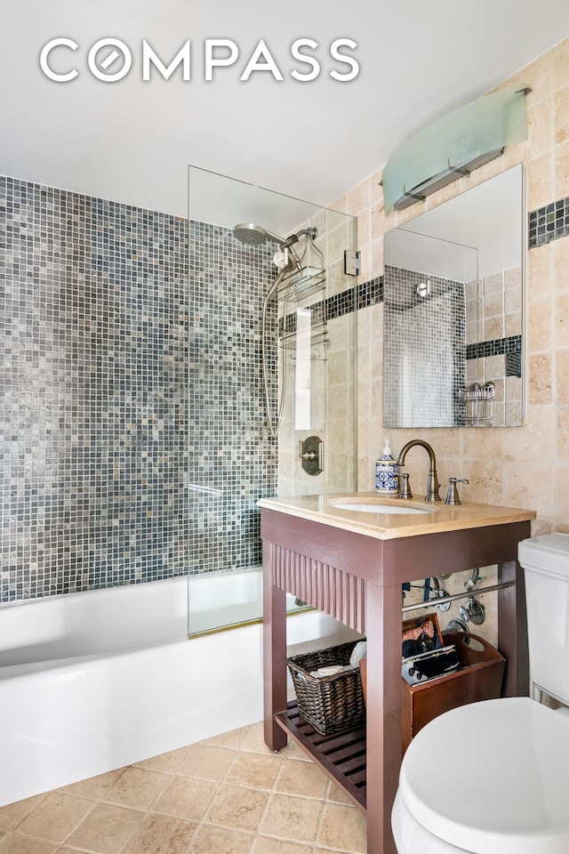 350 E 62nd St Unit 4B, New York City, NY 10065 - full bathroom featuring tile walls, toilet, bathtub / shower combination, and a sink