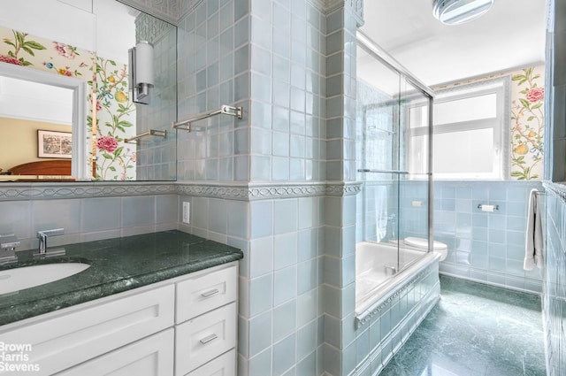 bathroom with tile walls, a tile shower, vanity, wallpapered walls, and tiled bath
