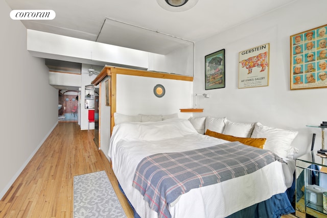 bedroom featuring hardwood / wood-style flooring, baseboards, and a closet