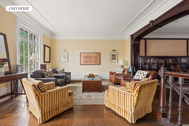 living area with wood finished floors and ornamental molding