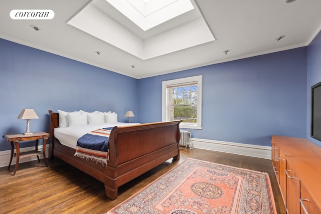 bedroom featuring dark wood finished floors, a skylight, radiator, baseboards, and ornamental molding