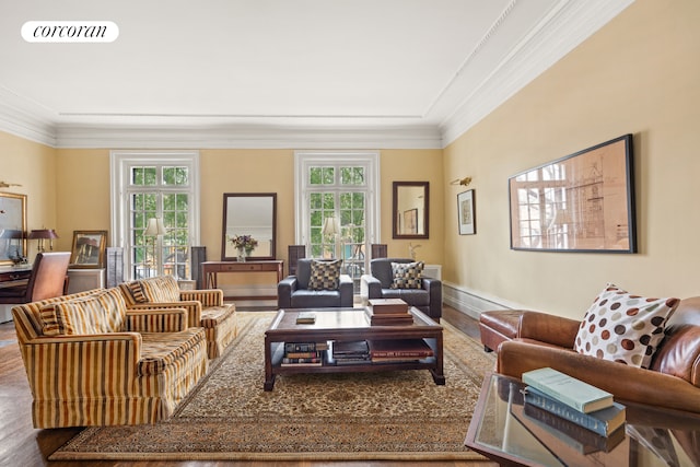 living room featuring wood finished floors, ornamental molding, and baseboards