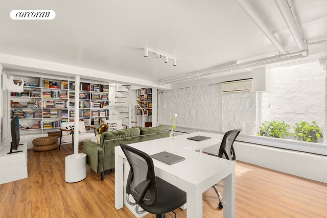 office space featuring a wall unit AC and wood finished floors