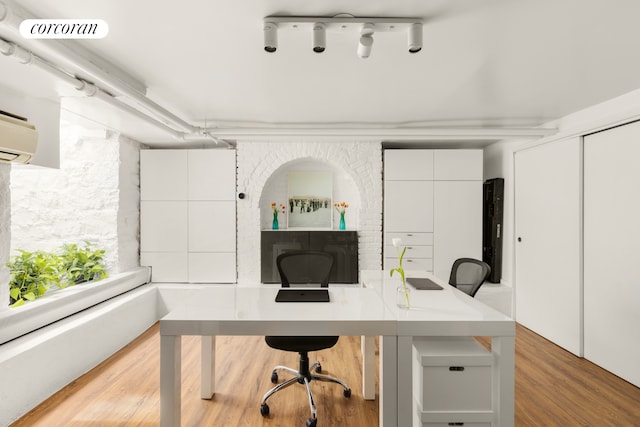 office area with a wall mounted AC and wood finished floors