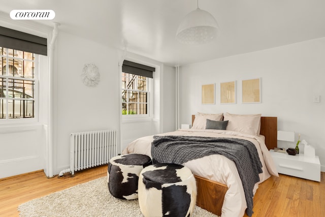 bedroom with radiator and wood finished floors