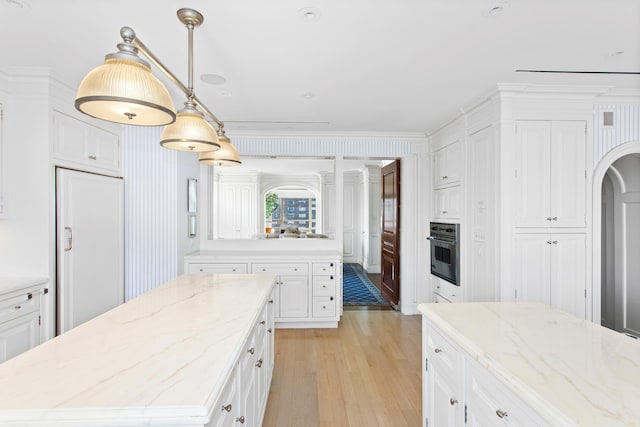 415 E 54th St Unit 25Gg, New York City, NY 10022 - kitchen featuring oven, paneled built in fridge, light wood finished floors, a center island, and white cabinetry