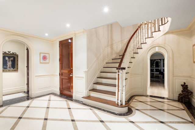 415 E 54th St Unit 25Gg, New York City, NY 10022 - entrance foyer with arched walkways, inlaid floor details, a decorative wall, stairs, and recessed lighting