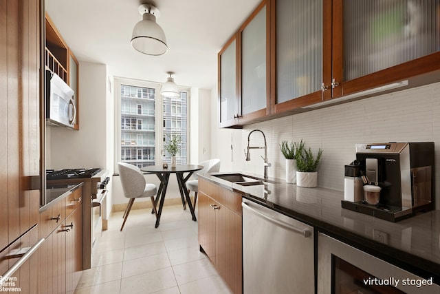250 E 53rd St Unit 1502, New York City, NY 10022 - kitchen with appliances with stainless steel finishes, tasteful backsplash, beverage cooler, glass insert cabinets, and light tile patterned floors