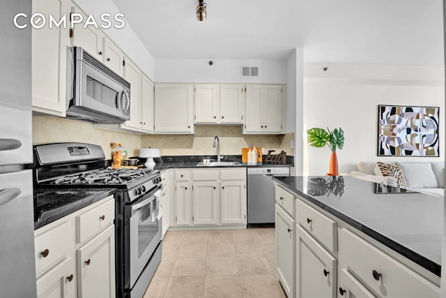 2235 Frederick Douglass Blvd Unit 2L, New York City, NY 10027 - kitchen featuring stainless steel appliances, a sink, decorative backsplash, and white cabinets