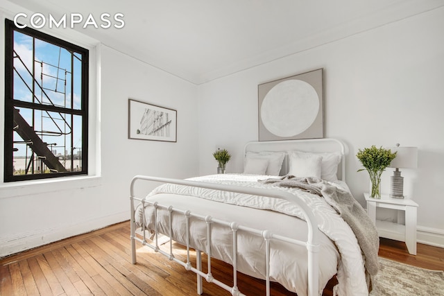 bedroom with hardwood / wood-style flooring and baseboards