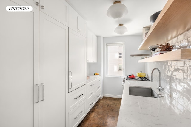105 W 13th St Unit 4C, New York City, NY 10011 - kitchen featuring open shelves, a sink, light stone countertops, white cabinets, and decorative backsplash