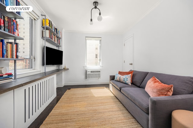 living area with ornamental molding, dark wood finished floors, baseboards, and a wall unit AC