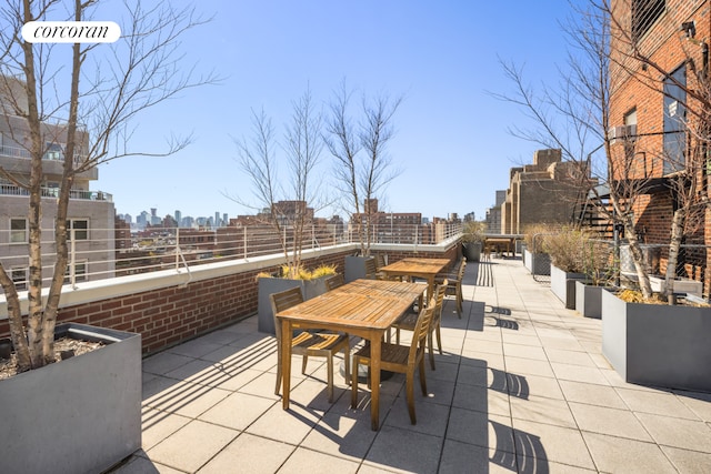 view of patio / terrace with a view of skyline and outdoor dining area