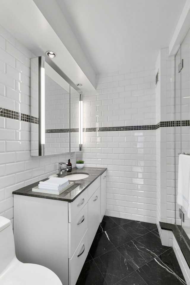 411 E 53rd St Unit 19D, New York City, NY 10022 - bathroom with tile walls, a shower stall, toilet, vanity, and marble finish flooring