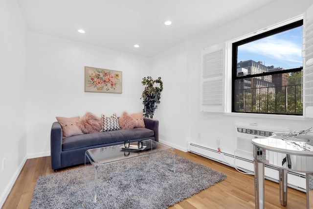 living area featuring a baseboard radiator, wood finished floors, recessed lighting, and baseboards