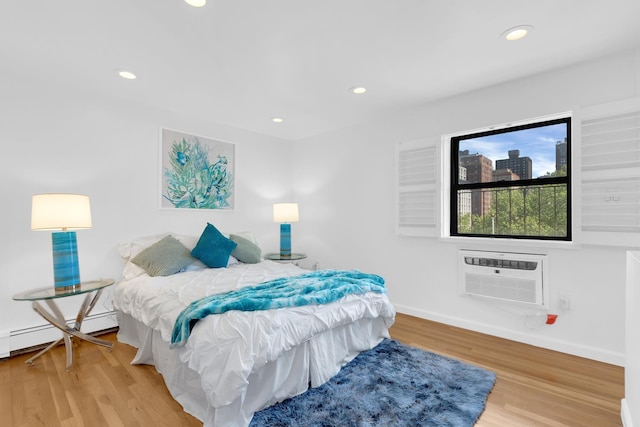 302 E 19th St Unit 3B, New York City, NY 10003 - bedroom featuring recessed lighting, wood finished floors, an AC wall unit, and baseboards
