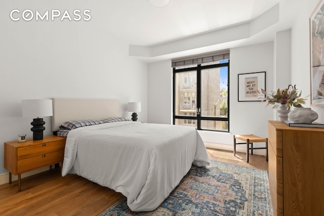 bedroom featuring wood finished floors and baseboards