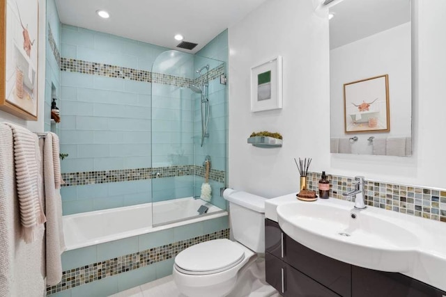 bathroom with tiled shower / bath, toilet, vanity, recessed lighting, and backsplash