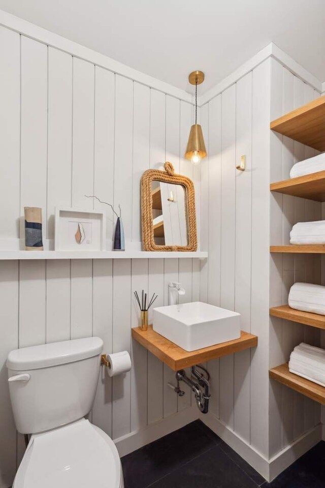 bathroom with a sink, toilet, and tile patterned floors